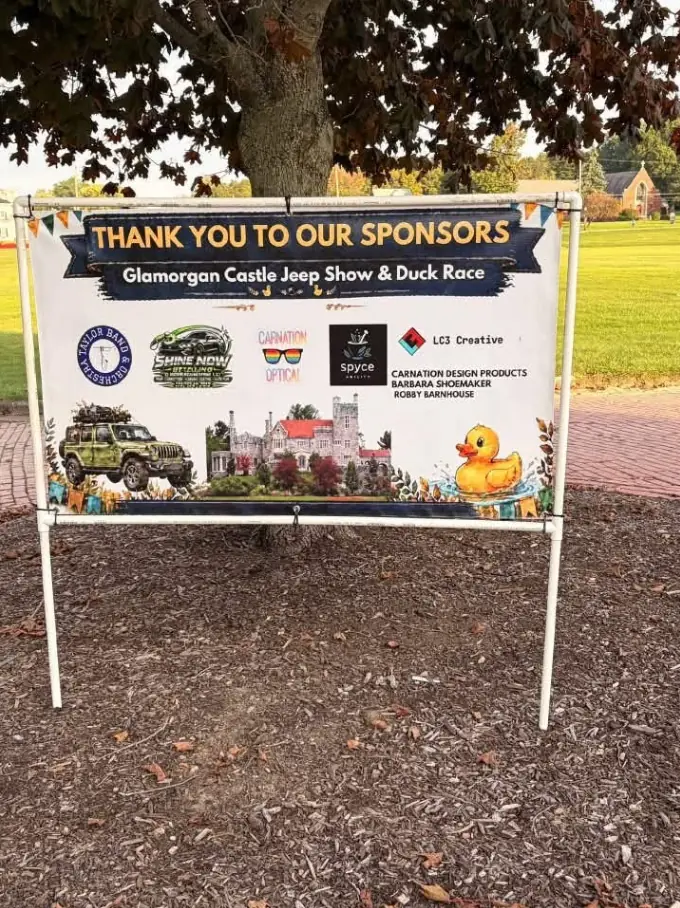 A Thank You to Our Sponsors banner for the Glamorgan Castle Jeep Show & Duck Race, with the LC3 Creative logo among the sponsors, displayed under a tree on the castle lawn.